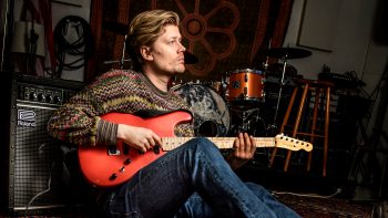Porträtt av Henning Sernhede med gitarr.