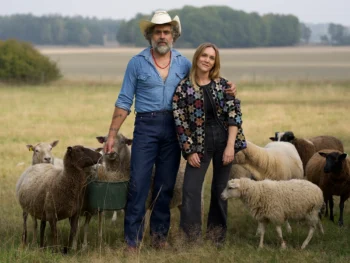 Kalle och Brita Zackari med några får på en äng. Pressbild från TV-serien Hjälp vi har köpt en bondgård.